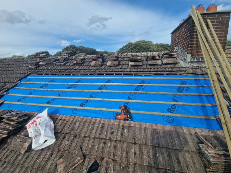Tiles stripped back to new breathable membrane and battens