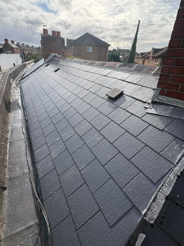 Newly laid natural slate roof with lead detailing